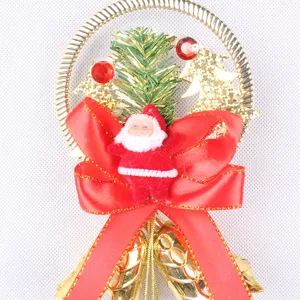 Detail of a Christmas bell ornament featuring a red bow, golden bells, and Santa Claus