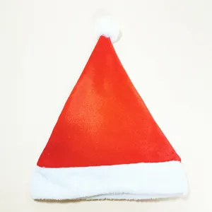 Primo piano del velluto rosso e del bordo di peluche bianco di un cappello di Babbo Natale
