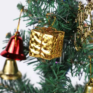 Detailed shot of golden gift box and bells Christmas tree hanging ornaments