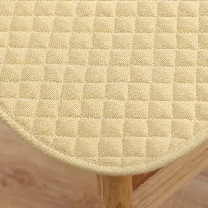 Nahaufnahme Detail des gelben gesteppten Stuhlkissens mit sauberer Naht und weicher Textur.