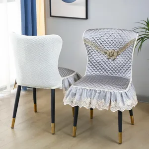 Vue détaillée de housses de chaise matelassées avec bordure en dentelle et broderie florale.