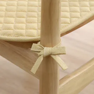 Nahaufnahme eines gelben gesteppten Stuhlkissens mit schöner Bindeschleife für Esszimmer.