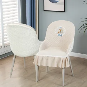Vue détaillée de la housse de chaise de salle à manger matelassée avec broderie de cerf.
