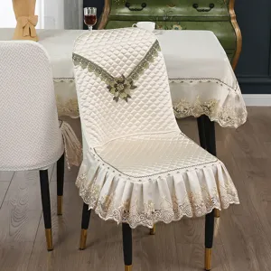 Beige gesteppter Esszimmerstuhlbezug mit feiner Spitzenborte und gestickten Blumen Details.
