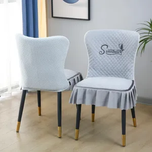 Vue rapprochée de la housse de chaise matelassée grise avec volants et broderie délicate.