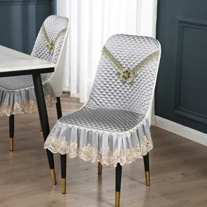 Detailansicht des grauen, gesteppten Esszimmerstuhlbezugs mit elegantem Goldspitzenmuster.