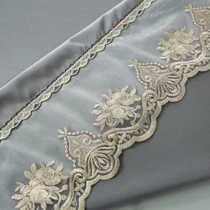 Detailansicht des grauen Eisseide Stuhles mit eleganter beigen Spitzenstickerei und feiner Arbeit.