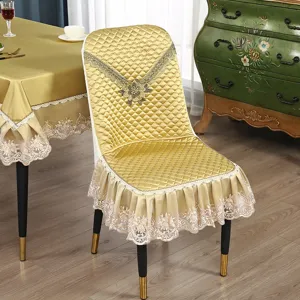 Elegante goldfarbene Stuhlbezüge mit Steppdesign, edler Spitzenborte und floralem Stickmuster.