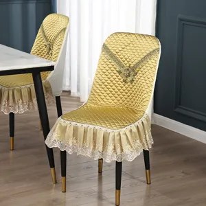 Goldener gesteppter Esszimmerstuhlbezug mit eleganter Spitzenrand und Rückenstickerei.