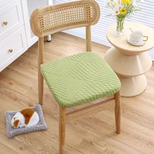Detailed view of the thickened green embossed knit chair cushion placed on a wooden chair.