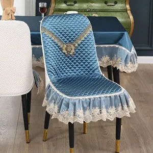 Detail des blauen Stuhlbezugs mit edler goldener Spitzenstickerei und hochwertigem Steppgewebe.