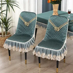 Detailansicht eleganter türkisfarbener Stuhlhussen mit Steppstoff, Spitzenrüschen und Blumen.