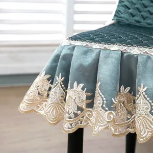 Detailed view of dark green quilted dining chair cover featuring elegant gold embroidery and lace.