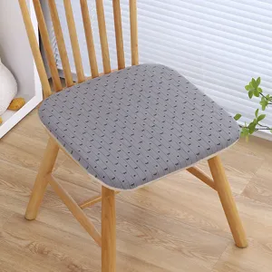 Dettaglio cuscino seduta in memory foam grigio con grazioso motivo a fiocco su sedia.
