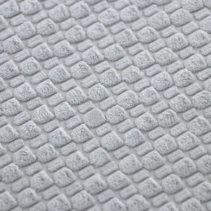 Close-up detail of gray plush seat cushion fabric texture, soft and warm tactile view.