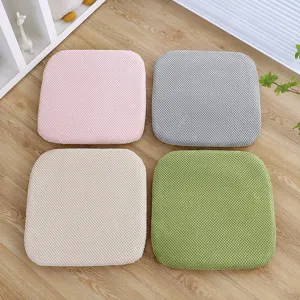 Primo piano di quattro cuscini quadrati colorati disposti in modo ordinato sul pavimento.
