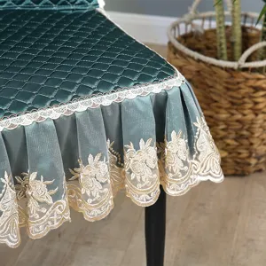 Detail shot of dark green quilted dining chair cover with elegant lace embroidery skirt.
