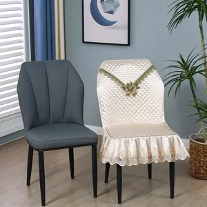 Quilted dining chair cover with elegant lace skirt and embroidered floral detail home decor.