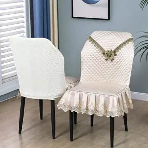 Beige quilted chair cover with elegant lace trim and gold embroidery, universal fit for dining.