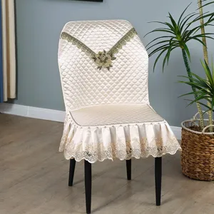 Detailed view of quilted dining chair cover featuring elegant lace trim and embroidered floral decor.