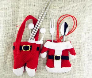 Festliche Weihnachtsmann-Besteckhalter mit Gabeln und Löffeln auf rustikalem Sackleinen