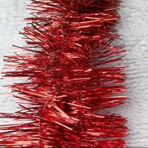 Close-up macro detail showing the fine texture of shimmering red Christmas tinsel garland