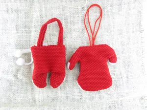 Detailansicht der roten Weihnachts-Besteckhalter in Form von Mini-Pullover und Hose.