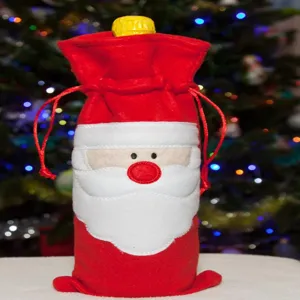 Detalle de una funda de fieltro rojo para botellas de vino con diseño de Papá Noel.