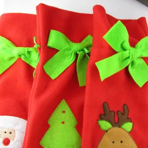 Close-up of festive Christmas wine bottle covers featuring Santa, tree, and reindeer motifs