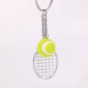 Detalle de un llavero con mini raqueta de tenis y pelota amarilla flúor