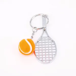 Vista de detalle de un llavero creativo con mini raqueta de tenis y pelota naranja vibrante.