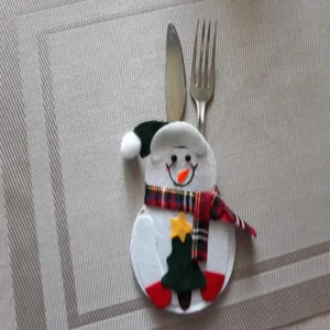 Nahaufnahme eines festlichen Schneemann-Besteckhalters mit Metallmesser und Gabel