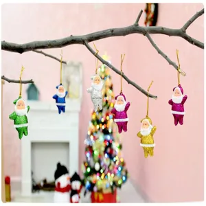 Set di decorazioni natalizie colorate con Babbo Natale glitterato su rami in scena festiva