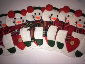 Detail von weihnachtlichen Schneemann-Bestecktaschen aus Filz mit Schals und Knöpfen