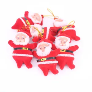 Vista dettagliata di piccoli ornamenti di Babbo Natale in peluche rosso con lacci dorati