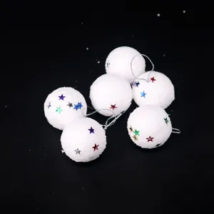 Detalle de bolas de nieve de Navidad de espuma blanca con estrellas de colores y cordón plateado