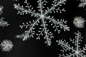 Detailed view of white plastic Christmas snowflake ornaments with sparkling iridescent tinsel