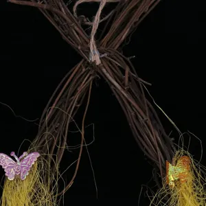 Close-up of Easter vine wreath detailing dried rattan texture and glitter butterfly ornaments.
