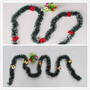 Split view of dark green Christmas tinsel garland with white tips and bow details
