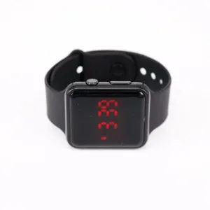 Detalle de reloj digital LED negro cuadrado con pantalla roja y correa de silicona.