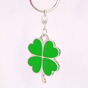 Dettaglio di un portachiavi a quadrifoglio in lega d'argento con smalto verde brillante.