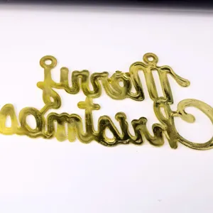 Detailansicht eines goldenen Merry Christmas Dekoschilds mit metallischem Glanz