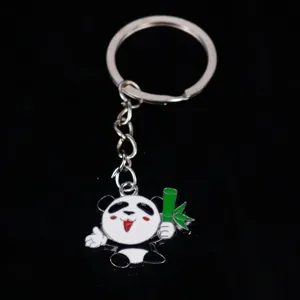 Detailed view of a cute cartoon panda metal keychain holding a green bamboo stalk