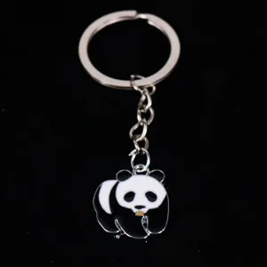 Macro detail of cute panda metal keychain showing black and white enamel craftsmanship.