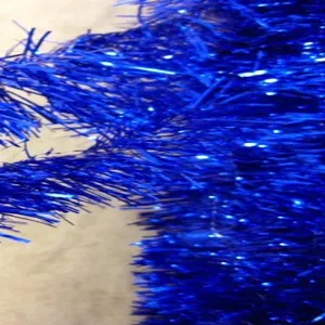 Détail macro de la texture de la guirlande de Noël bleu métallique étincelant.