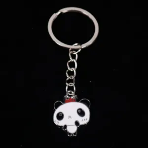 Close-up detail of a cute cartoon panda keychain with red crown and metal ring