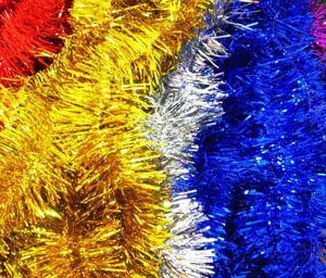 Gros plan de guirlandes de Noël métalliques colorées en or, bleu et argent