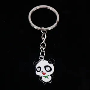 Close-up of cute cartoon panda enamel metal keychain pendant on black background