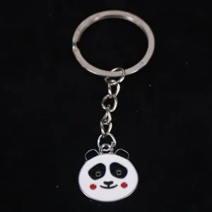 Cute metal panda head keychain charm with red cheeks and enamel finish on black backdrop
