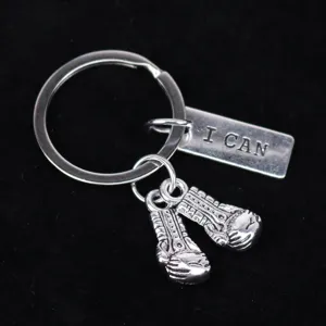 Detail van zilveren bokshandschoen sleutelhanger met gegraveerd "I CAN" label.